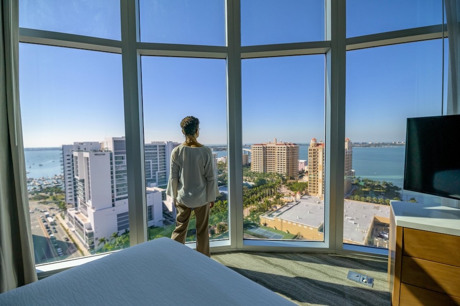 woman looking out of guest suite view of sarasota hotel