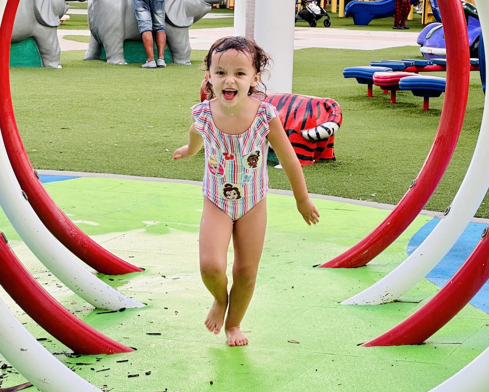 little girl playing outside in payne park sarasota fl at splash pad