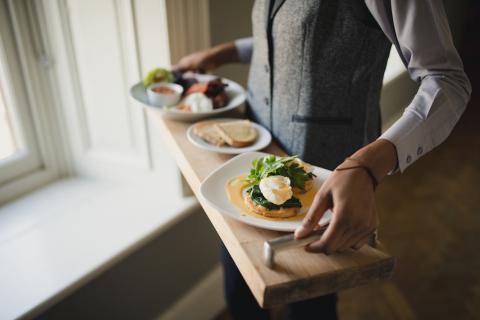 Person holding a tray of delicious dishes