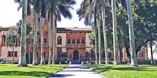 Front of the Ringling Museum lined with palm trees.