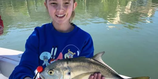 Girl holding a fish she caught