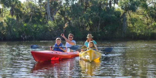 Family in red and yellow kayaks on the water