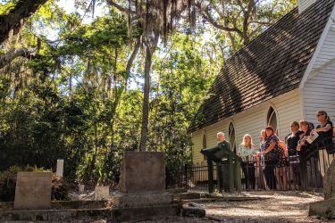 Group looking at old grave stones next to a historic church