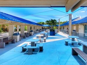 Shade Sails at Lido Beach Pavilion - These sails really transform the outdoor eating and sitting area. The triangular-shaped canopies offer shade and screen out the sunshine. The Shade material is double-sided, blue on the top and white on the bottom. Sails are able to withstand 74 mph winds but have to be removed if forecasted to get higher.  Poles vary in sizes from 12 feet to 16 feet tall.
