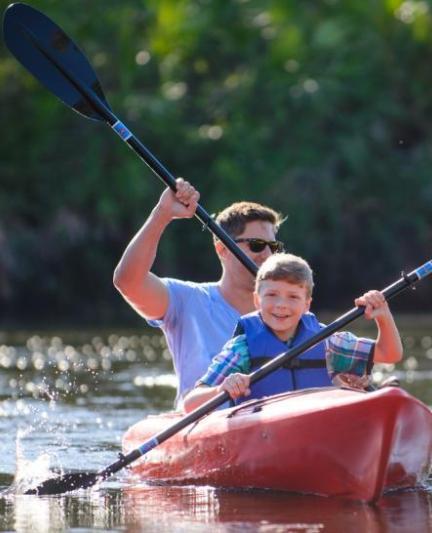 Man and Sun kayaking on river. 