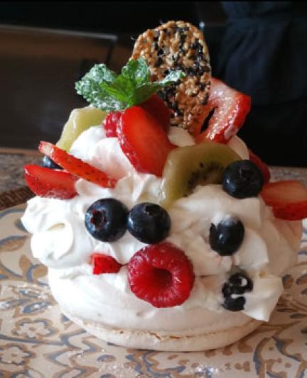 The Pavlova, a stunning meringue-based cake with a sesame snap, whipped cream, raspberries, blueberries, strawberries and kiwi.. Photo Credit: Abby Weingarten.