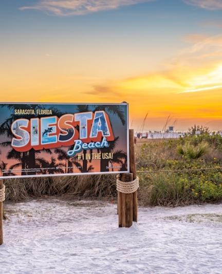 sign on siesta key beach at sunset