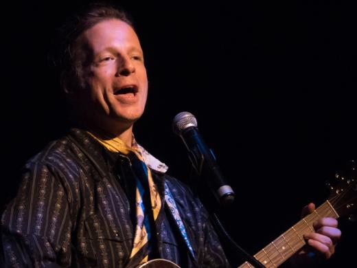 Cast Member, Joe Casey, sings and plays the guitar.