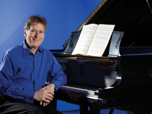 Levin sitting by a Piano