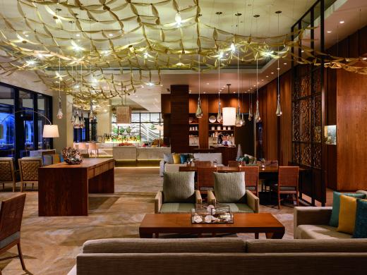 An image of an indoor restaurant with neutral furnishings and hanging lights