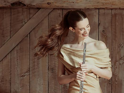 Emi Ferguson in gold dress holding flute