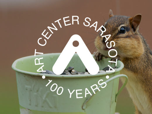 Image of a chipmunk eating seeds out of a small bucket, with Art Center Sarasota's logo