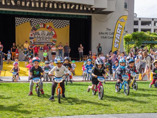 A photo of dozens of Strider riders coming down the start gate ramp, racing eagerly towards victory at the Strider Cup World Championship.