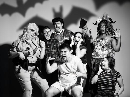 A black and white photo of some of the cast of bat boy in a horror movie style