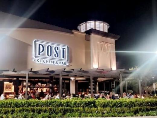 Post Kitchen & Bar exterior and patio illuminated at night in the UTC district.