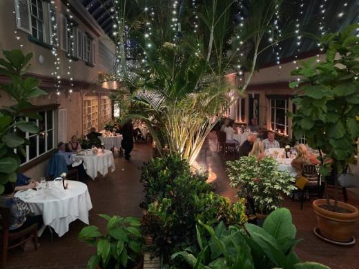 Michael's On East atrium dining room with tropical plants and string lights.