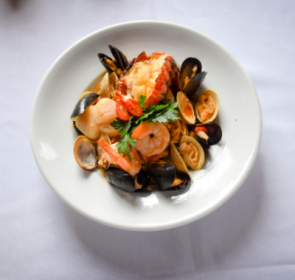 Plate of seafood dish with muscles and shrimp.