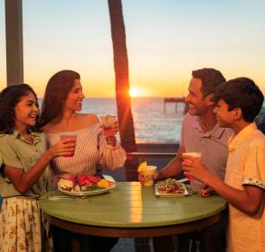 family dining at sunset at fins overlooking venice fishing pier