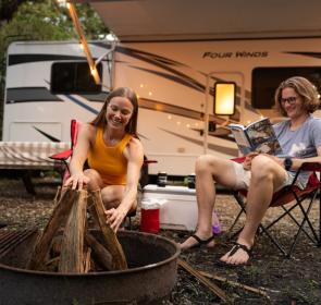 Couple in camping chairs outside RV