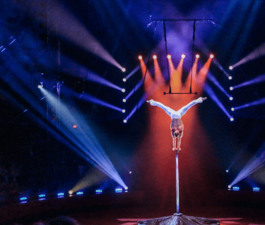 Circus Performer doing a hand stand stunt on tall pole