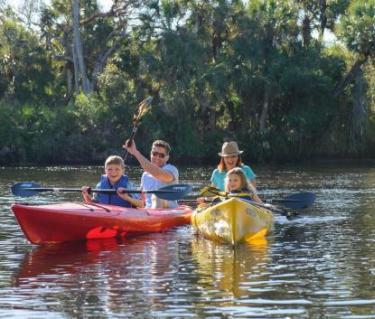 Family in red and yellow kayaks on the water