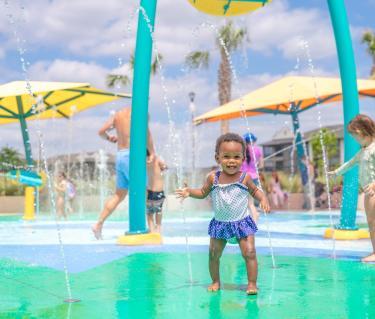 little girl cooling off at a splash pad in sarasota