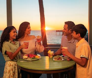 family dining at sunset at fins overlooking venice fishing pier