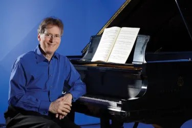 Levin sitting by a Piano