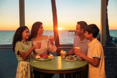 family dining at sunset at fins overlooking venice fishing pier