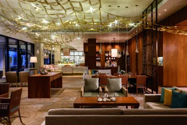 An image of an indoor restaurant with neutral furnishings and hanging lights