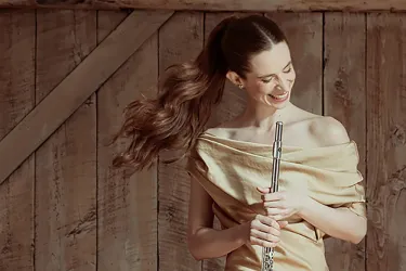 Emi Ferguson in gold dress holding flute