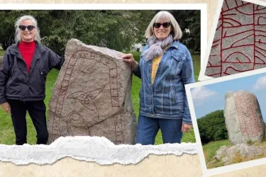 2 people posing with runestone, stones with carved rune inscriptions