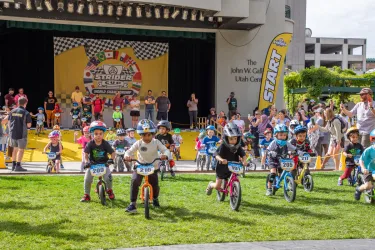 A photo of dozens of Strider riders coming down the start gate ramp, racing eagerly towards victory at the Strider Cup World Championship.